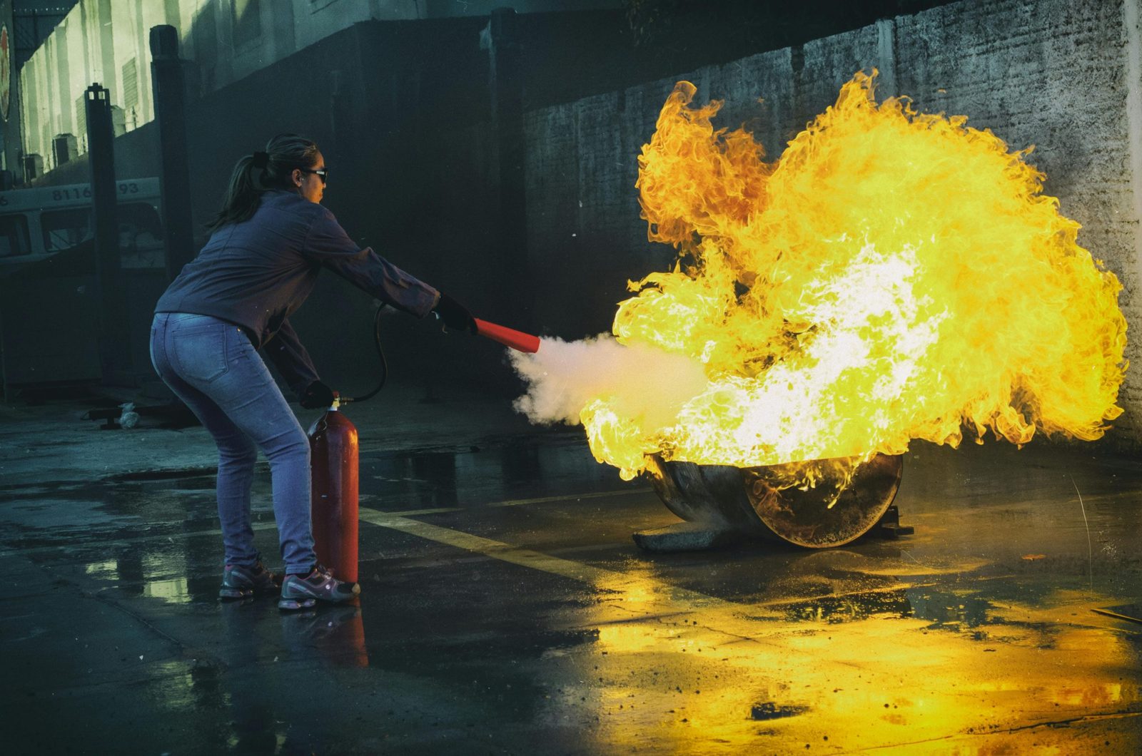 Löschübung: Eine Person löscht ein Feuer mit einem Feuerlöscher